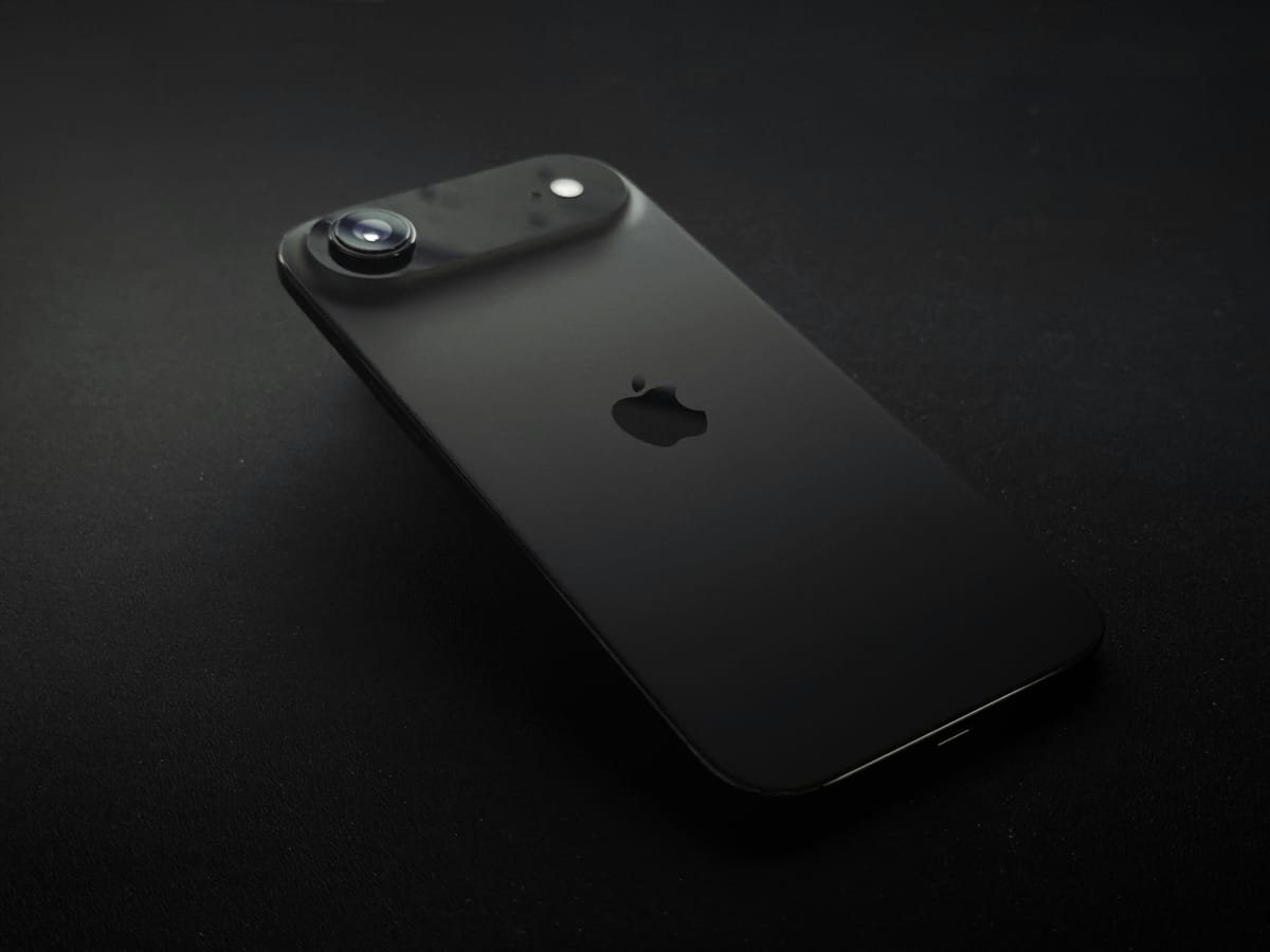 Schwarzes iPhone mit Apple-Logo auf dunklem Hintergrund