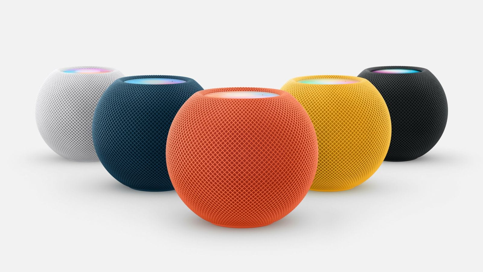 Fünf Apple HomePod mini in verschiedenen Farben mit leuchtender Siri-Touchfläche auf hellem Studiohintergrund